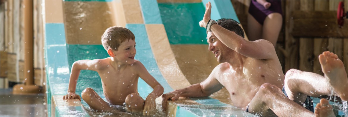A father and son enjoy playing in the kids pool